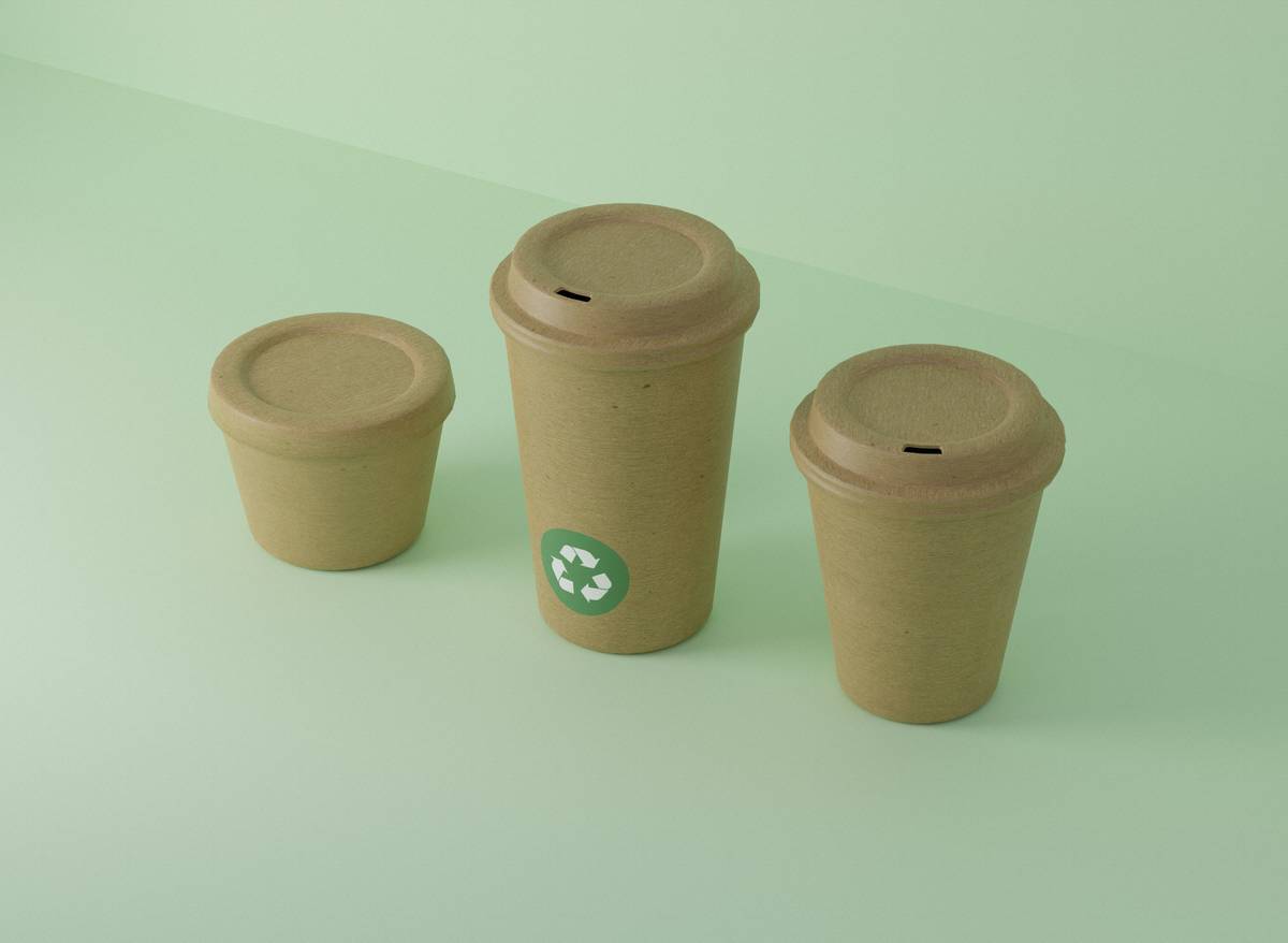 Close-up of biodegradable paper products for food decomposing in home compost bin with soil and worms