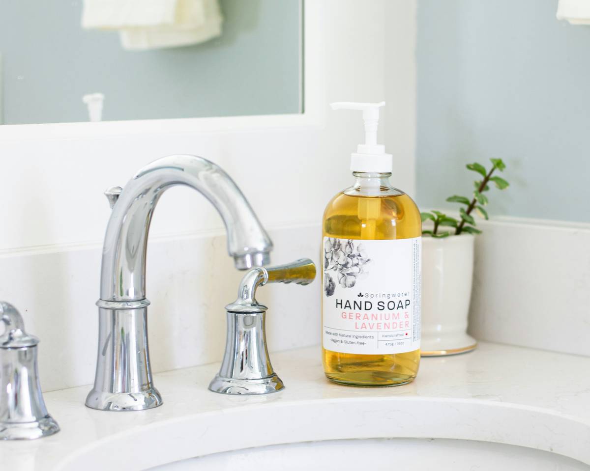 ecos plant based dish soap bottle next to clean dishes and fresh lemons